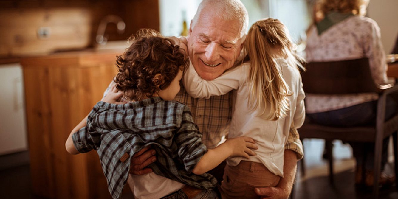 Kinder umarmen ihren Opa