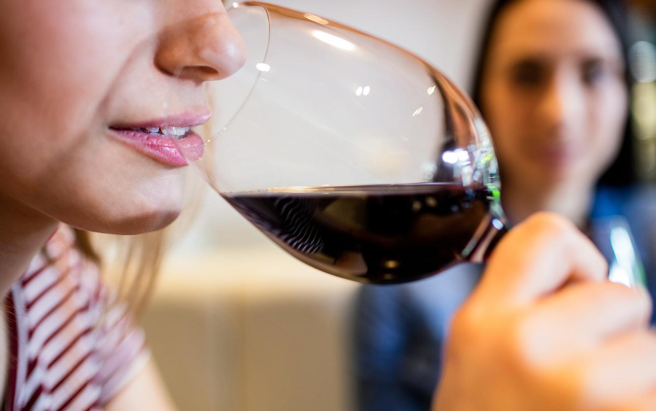 Eine Frau trinkt aus einem Rotweinglas