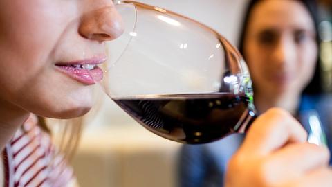 Eine Frau trinkt aus einem Rotweinglas - Foto: iStock / Wavebreakmedia