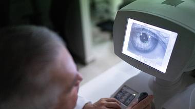 Arzt guckt Bild eines Auges an - Foto: iStock/FG Trade