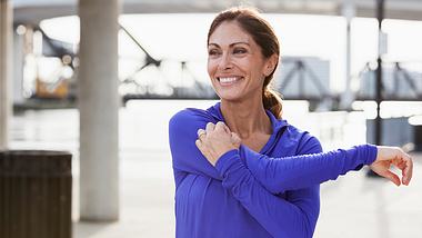 Eine Frau wärmt sich vor dem Sport auf - Foto: iStock/kali9
