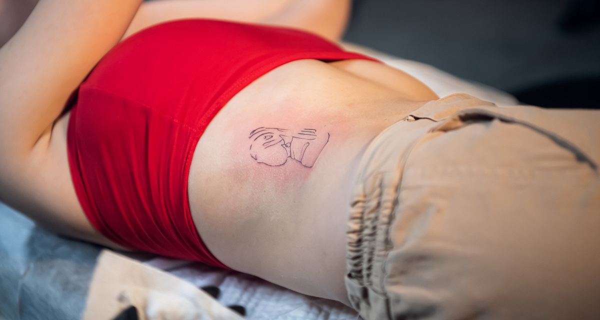 Junge Frau mit frisch gestochenem Tattoo