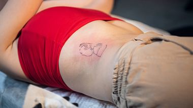 Junge Frau mit frisch gestochenem Tattoo - Foto: iStock/fpphotobank