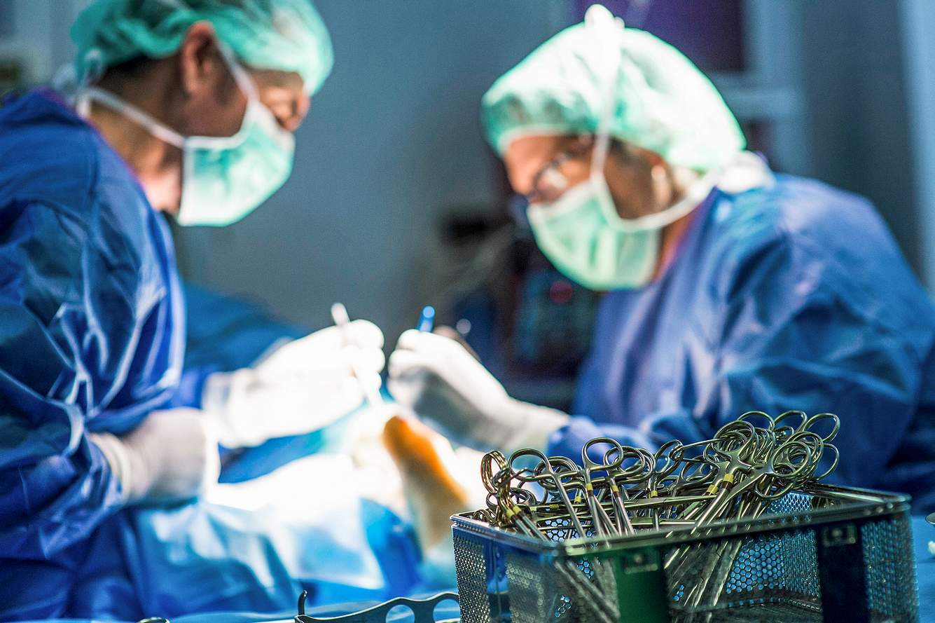 Ärzte bei Operation, im Vordergrund OP-Besteck