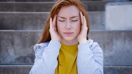 Frau mit Tinnitus hält die Hände auf die Ohren - Foto: iStock/tommaso79