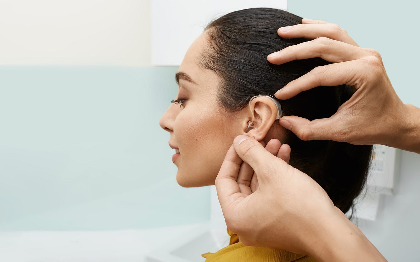 Frau bekommt Tinnitus-Hörgerät angepasst