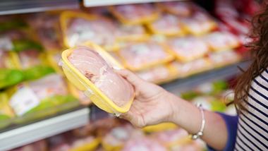 Frau wählt verpacktes frisches Hühnerfleisch im Supermarkt - Foto: iStock / nastya_ph