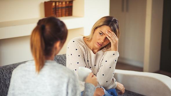 Eine Frau hört ihrer Freundin angestrengt zu - Foto: iStock_Emir Memedovski