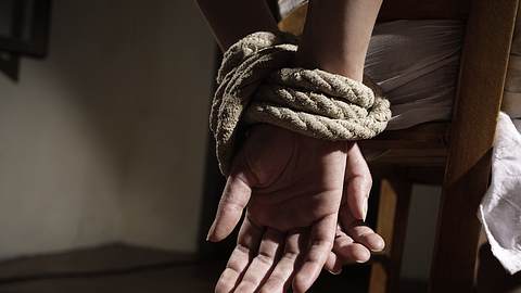 Eine Frau sitzt gefesselt an einem Stuhl - Foto: iStock/cyano66