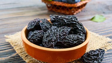 Trockenpflaumen in einer Holzschale - Foto: iStock/Maryna Iaroshenko