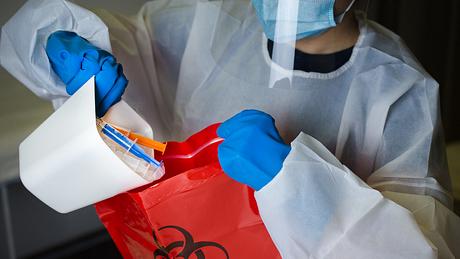 Ärztin entsorgt Impfmaterial - Foto: iStock / Radule Perisic