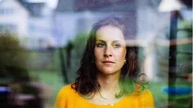 Eine Frau schaut nachdenklich aus dem Fenster - Foto: iStock/Matthias Lindner
