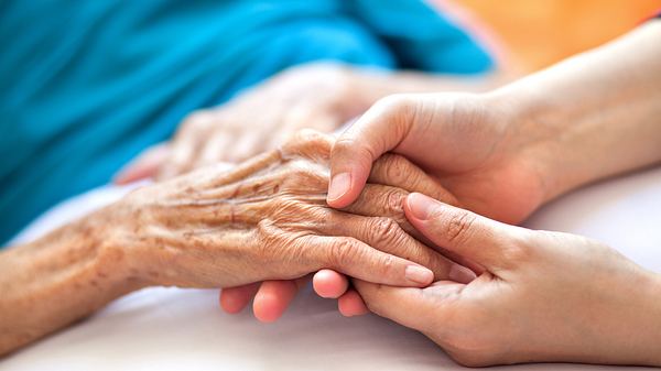 Ältere und junge Frau halten sich an den Händen - Foto: iStock/Barcin