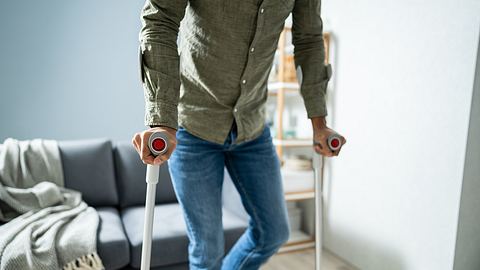 Mann stützt sich beidseitig auf Krücken - Foto: istock/andreypopov