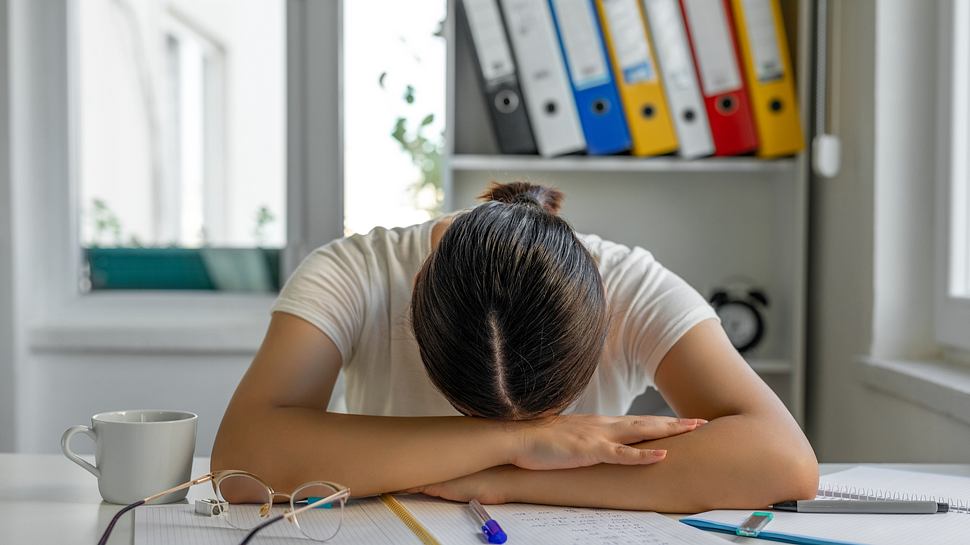 Eine Frau sitzt verzweifelt am Schreibtisch  - Foto: iStock/bymuratdeniz