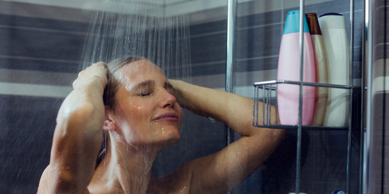 Eine Frau steht unter der Dusche
