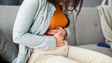 Eine Frau hält sich den Bauch - Foto: iStock/AndreyPopov