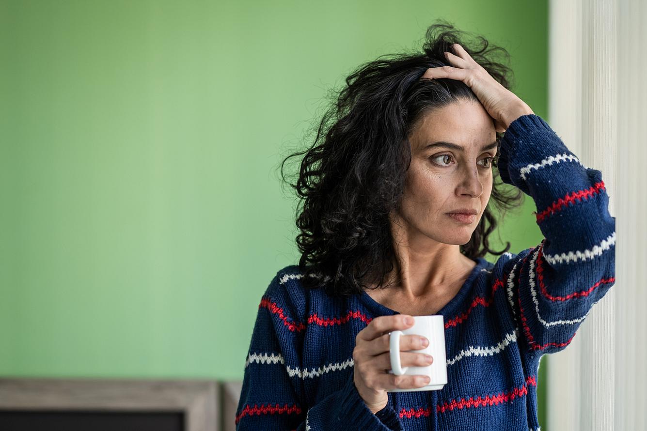 Sorgenvolle Frau trinkt Kaffee allein
