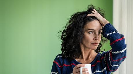 Sorgenvolle Frau trinkt Kaffee allein - Foto: iStock / valentinrussanov