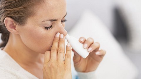 Eine Frau verwendet Nasenspray - Foto: iStock/CentralITAlliance