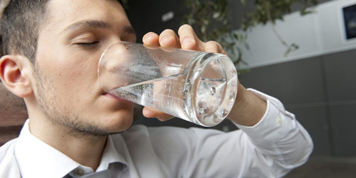 Mann trinkt Wasser und kann sich besser konzentrieren