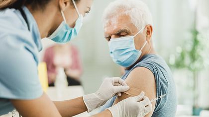 Ein Mann lässt sich gegen Corona impfen - Foto: iStock_MilanMarkovic