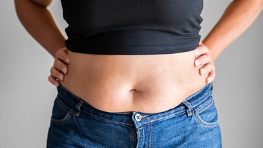 Eine Frau mit dickem Bauch in Jeans und kurzem Top - Foto: iStock_AndreyPopov