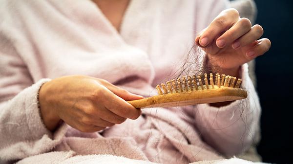 Eine Frau rupft Haare aus ihrer Bürste - Foto: iStock/Vahit Ozalp