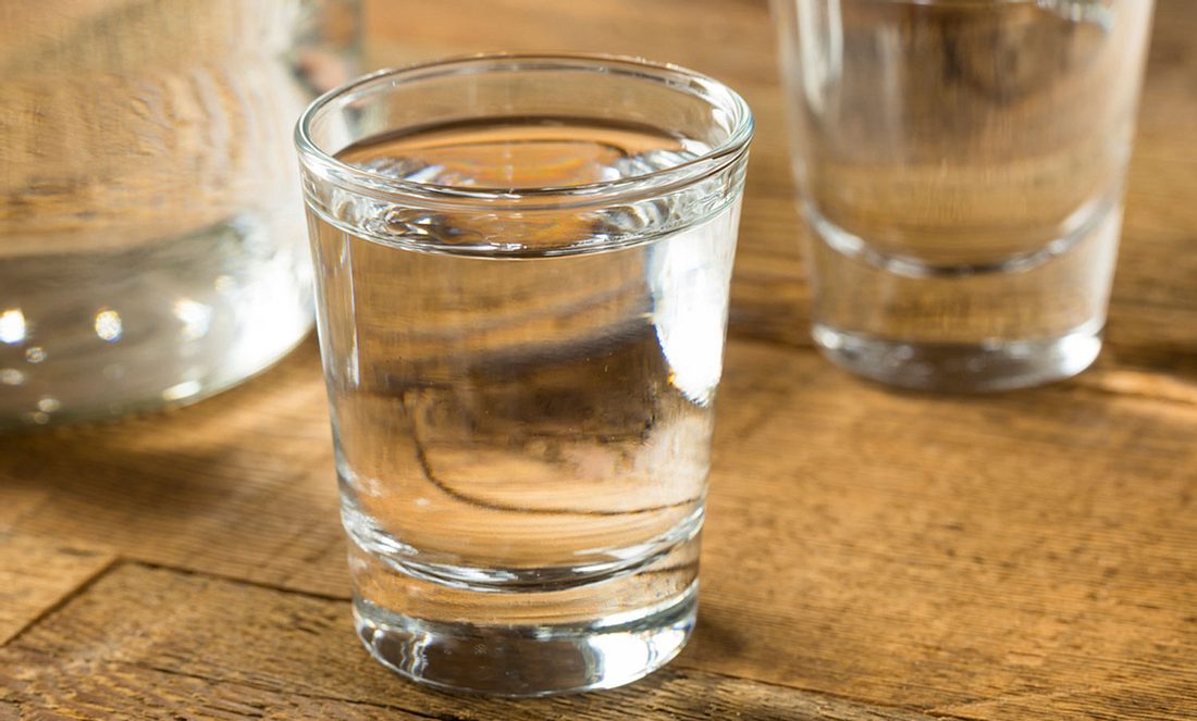 Wodka im Glas steht auf dem Tisch als ungewöhnliches Hausmittel gegen Fußgeruch