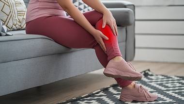 Eine Frau hält sich die linke Wade. - Foto: iStock / Staras