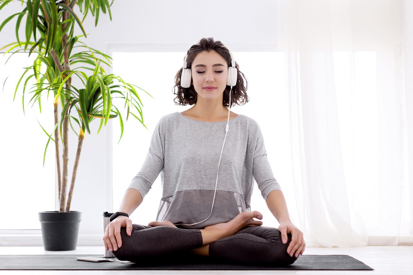 Frau macht Yoga mit Kopfhörern