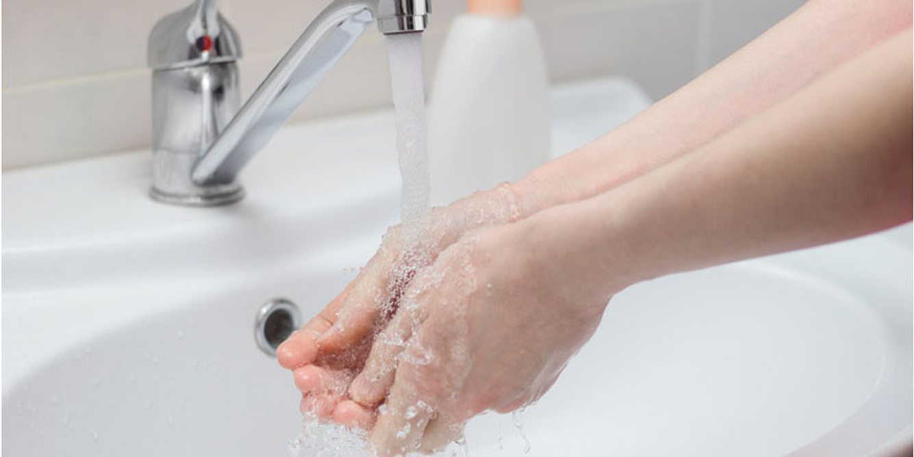 Hände unter kaltes Wasser