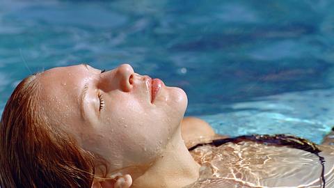 Frau entspannt im Pool - Foto: iStock/Mike_Kiev