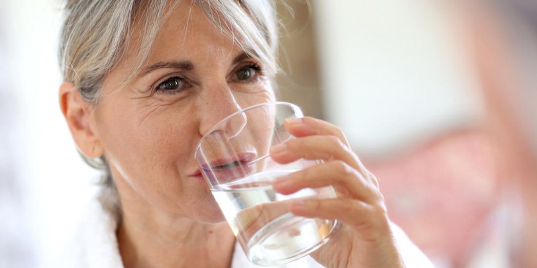 Frau trinkt ein Glas Wasser
