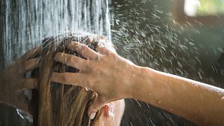 Eine Frau steht unter der Dusche - Foto: iStock/skynesher