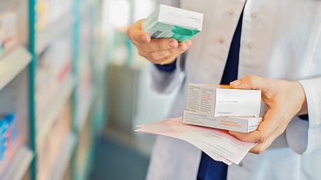 Eine Apothekerin mit mehreren Medikamenten-Schachteln in der Hand - Foto: istock_alvarez