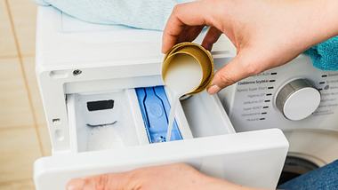 Person kippt Weichspüler in Waschmaschine - Foto: iStock/Anetlanda