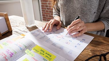 Frau mit zwei Wochenplanern - Foto: iStock/AndreyPopov