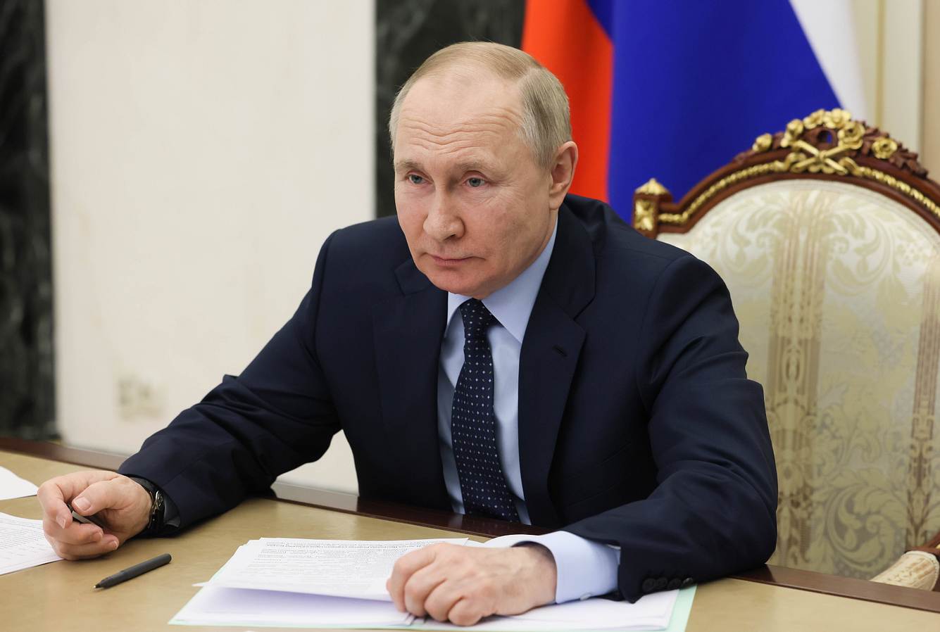 Wladimir Putin sitzt am Rednerpult