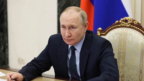 Wladimir Putin sitzt am Rednerpult - Foto: IMAGO/ITAR-TASS
