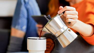 Frau schenkt sich Espresso aus einer Kanne ein - Foto: iStock/Morsa Images