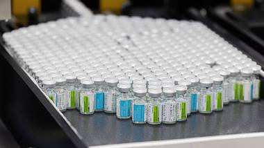 Viele Impfstoffampullen auf einem Förderband - Foto:  IMAGO/Belga