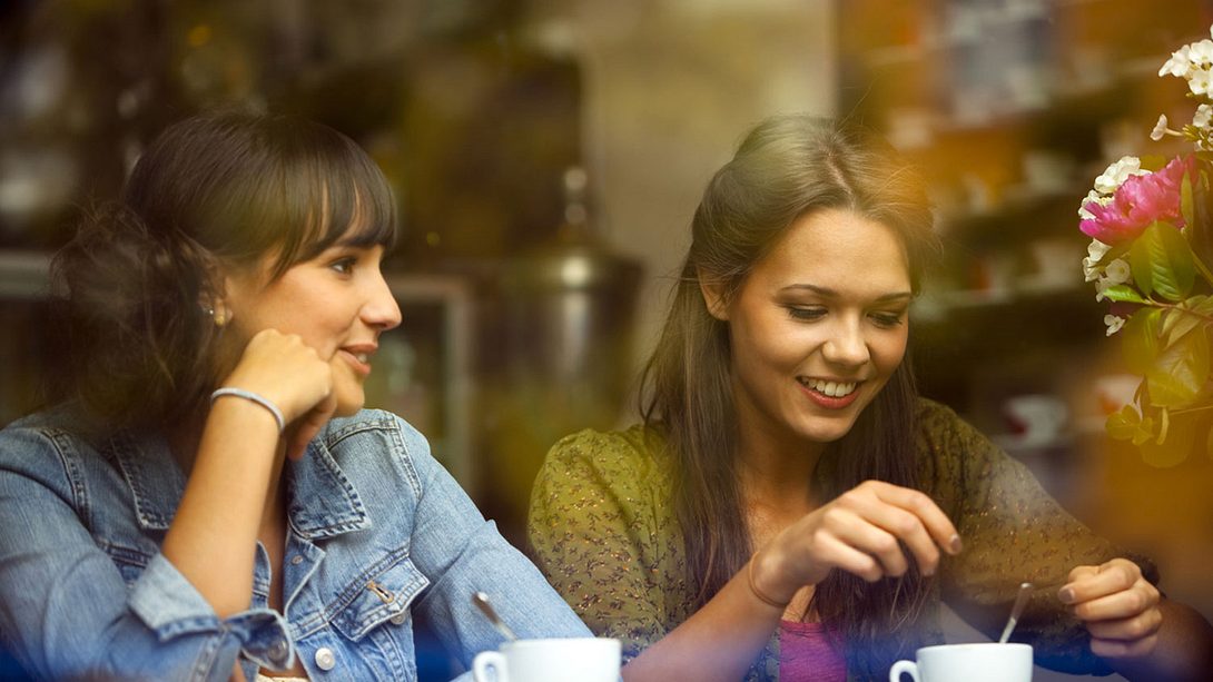 Zwei Freundinnen sitzen in einem Kaffee und unterhalten sich - Foto: iStock/Bim