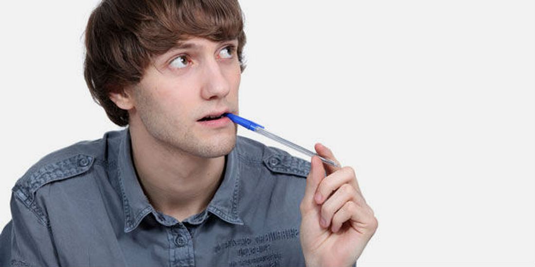 Mann mit Stift im Mund