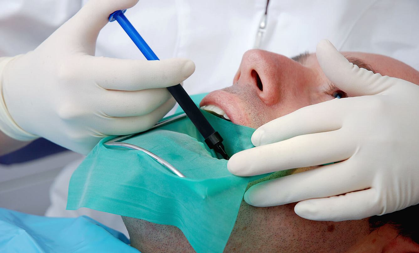 Mann wird vom Zahnarzt behandelt