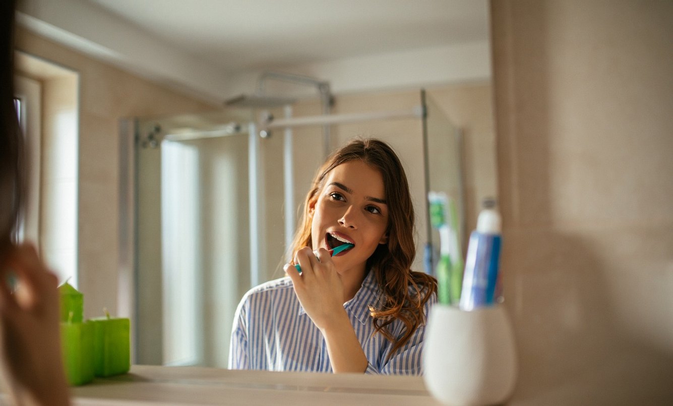 Junge Frau putzt sich die Zähne