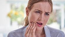 Eine Frau hat Zahnschmerzen.  - Foto: iStock / MachineHeadz 