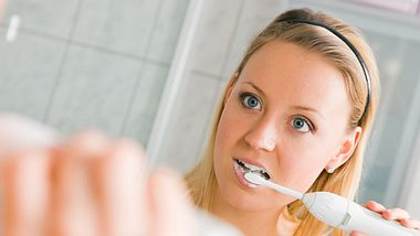 Frau putzt Zähne gegen Zungenbelag - Foto: Fotolia